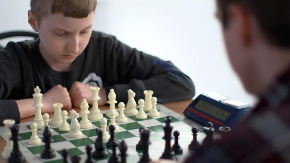 Deux joueurs concentrés devant un jeu d'échecs.