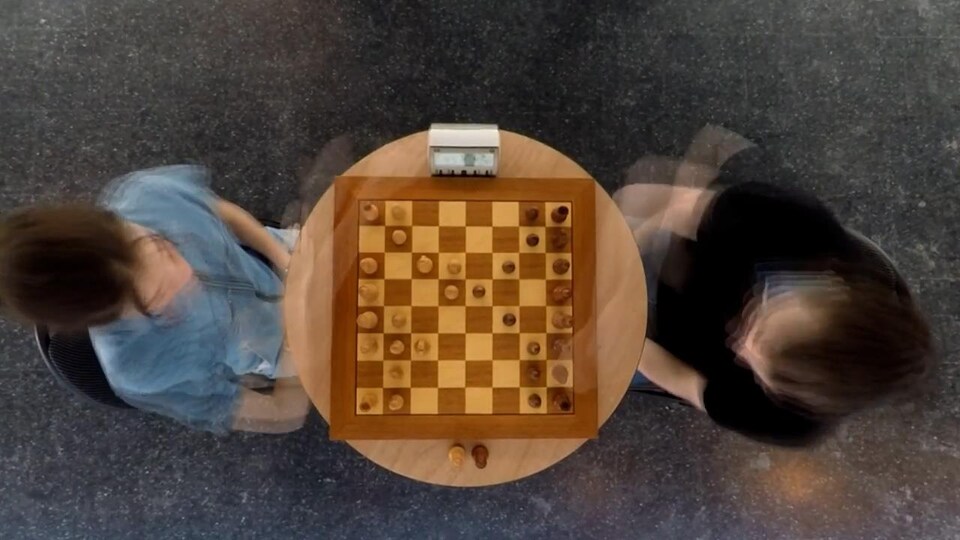 Deux joueurs devant un jeu d'échecs.