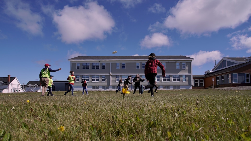 Young people play frisbee in the yard of the St-Joseph school.                         
