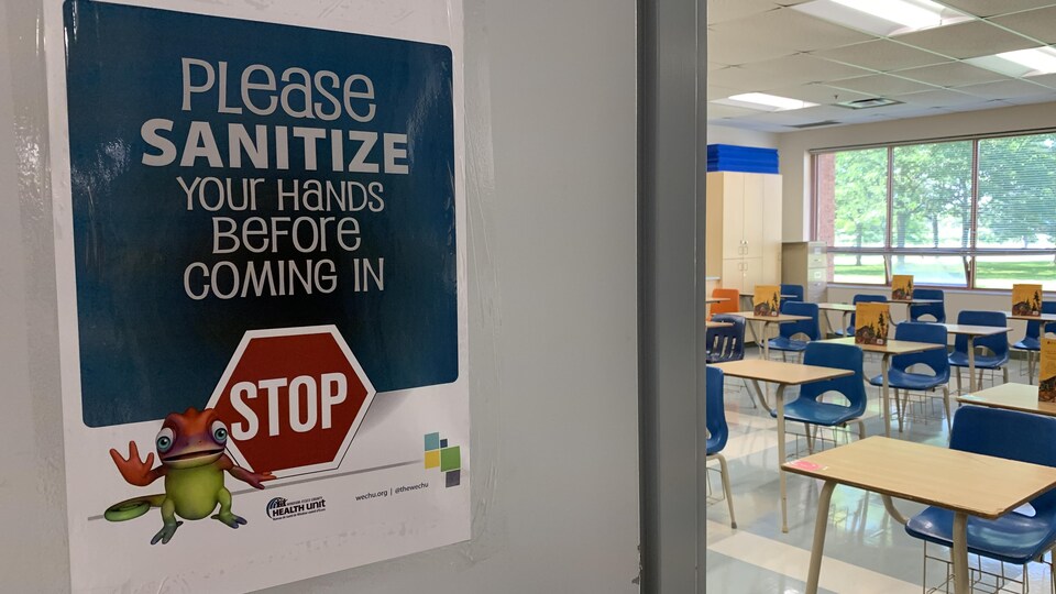 Une affiche collée sur une porte de classe et la classe en second plan.