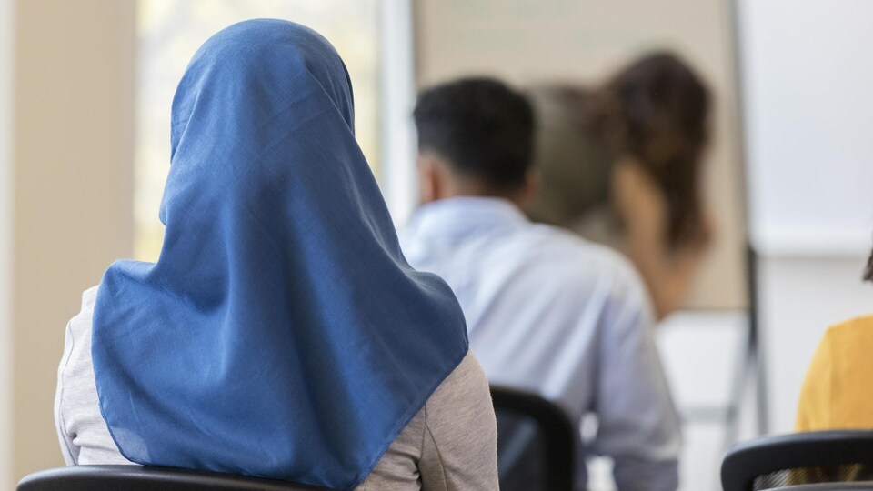 Une élève de dos porte un voile.