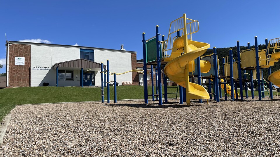 Un parc à jeux pour enfants devant une école.