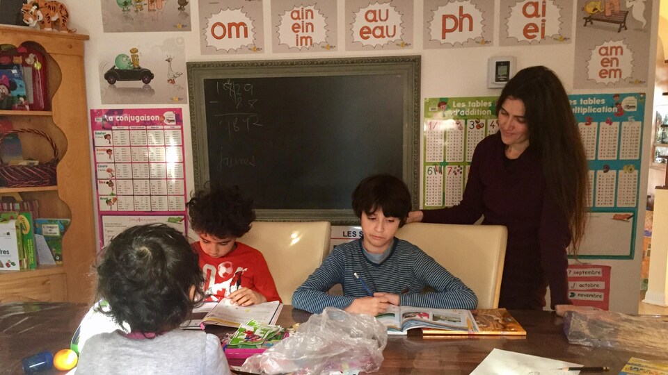 Cette mère de famille fait l'école à la maison avec ses trois enfants.