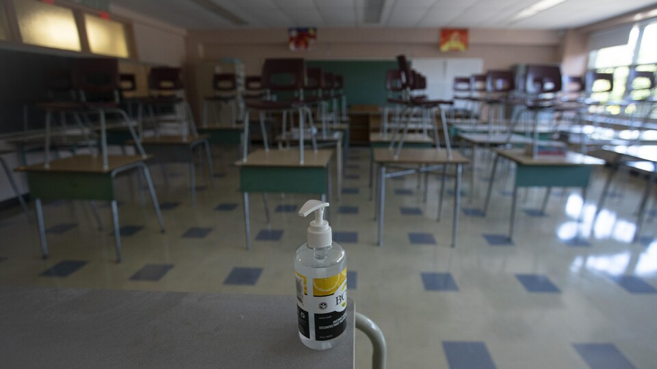 Une bouteille de gel désinfectant dans une salle de classe.