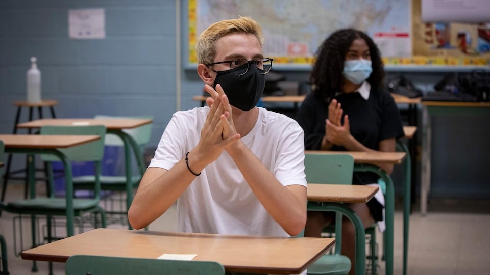 Deux élèves qui portent un masque en classe