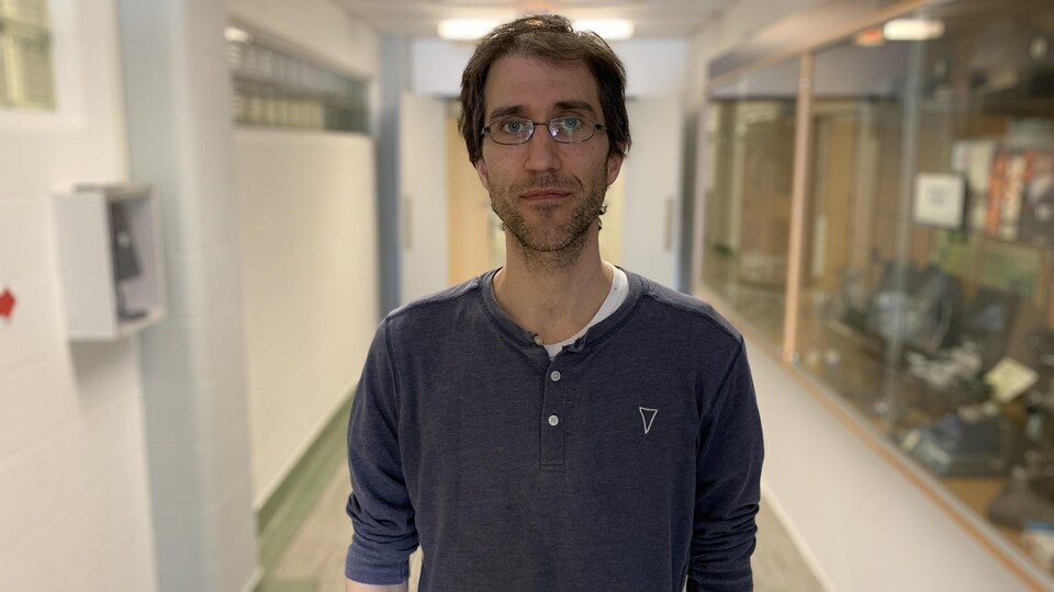 Samuel de Chavigny pose pour la photo dans un corridor.