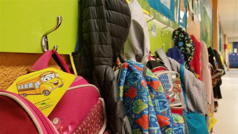 Des manteaux et des sacs à dos d'écoliers dans une école primaire