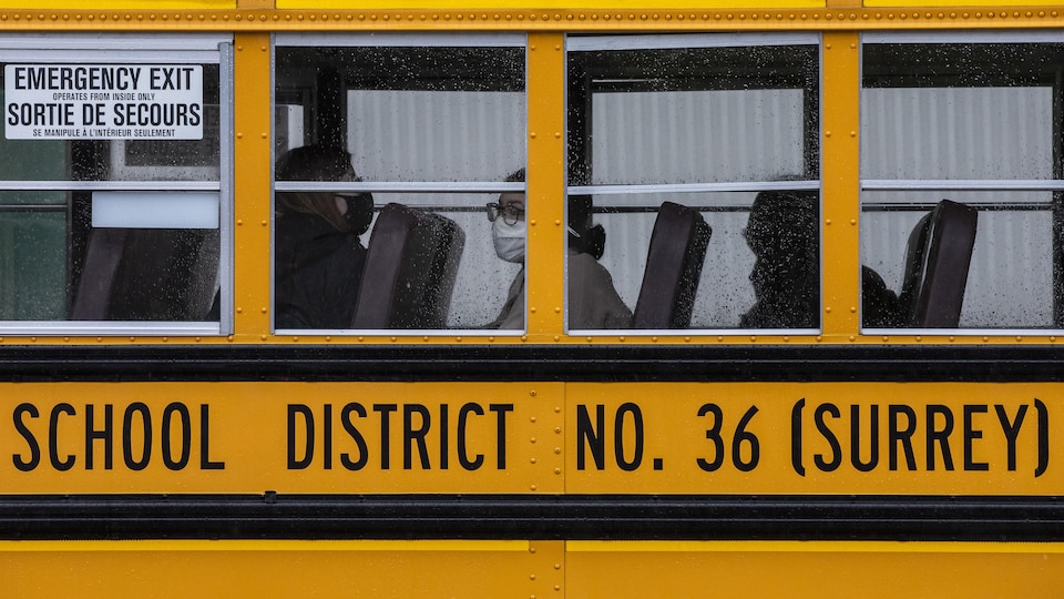 Trois élèves de l’école secondaire Earl Marriott sont assis dans un autobus scolaire le 4 janvier 2021.