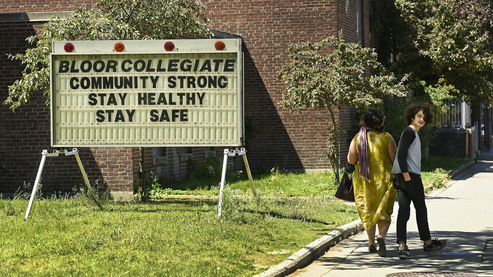 Une femme et un adolescent passent devant le Bloor Collegiate Institute, à Toronto, le 27 mai 2021.