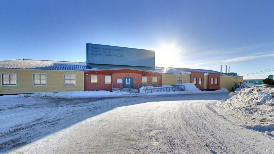 Une école en hiver devant le soleil. 
