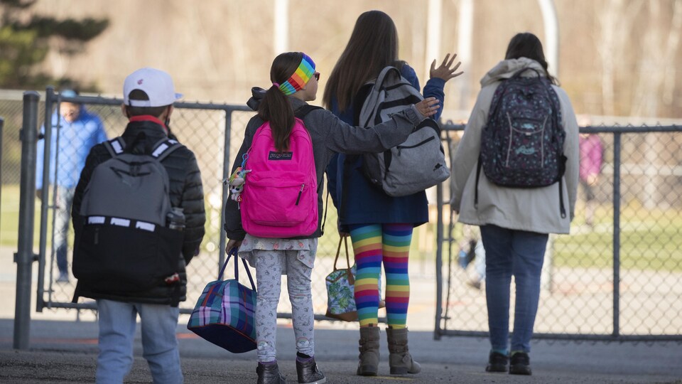 Des enfants gardent une bonne distance entre eux dans une cour d'école.