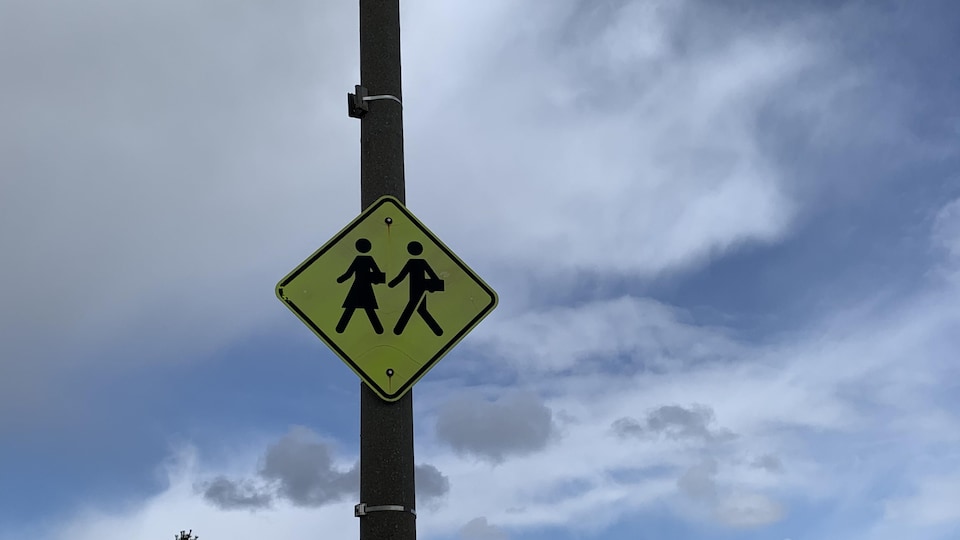Une pancarte avertissant les automobilistes à l'arrivée dans une zone scolaire.