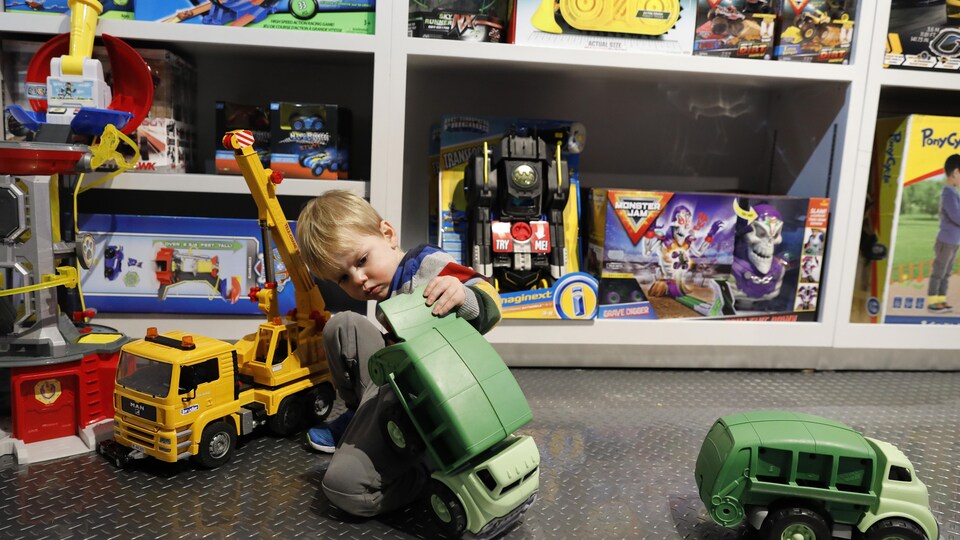 Un garçon joue avec un camion dans un magasin de jouets.