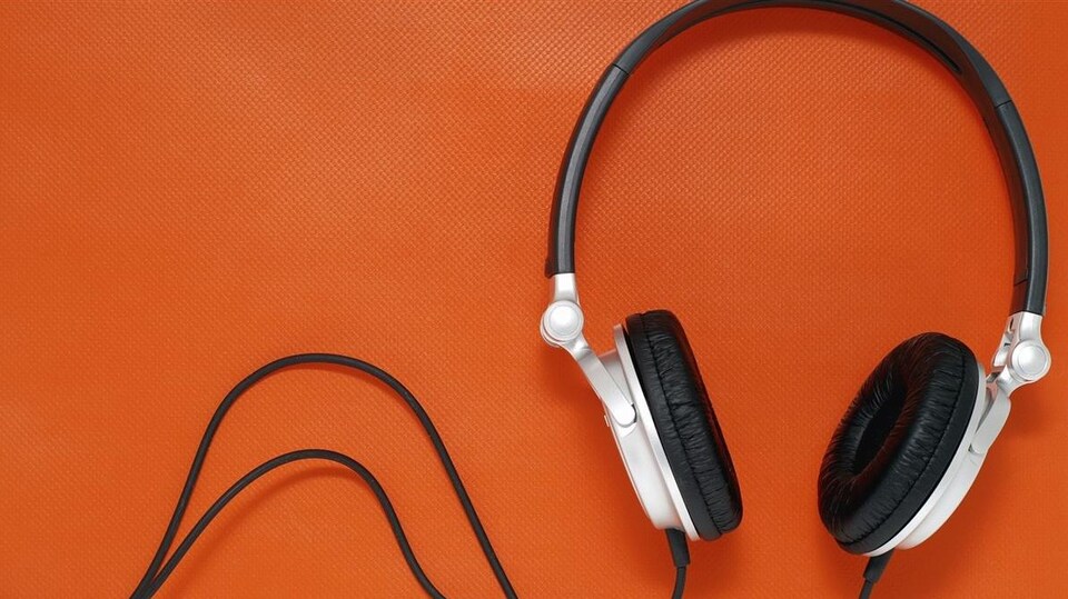 Un casque d'écoute blanc et noir sur fond orange