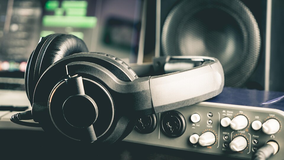 Des écouteurs placés sur une console d'enregistrement