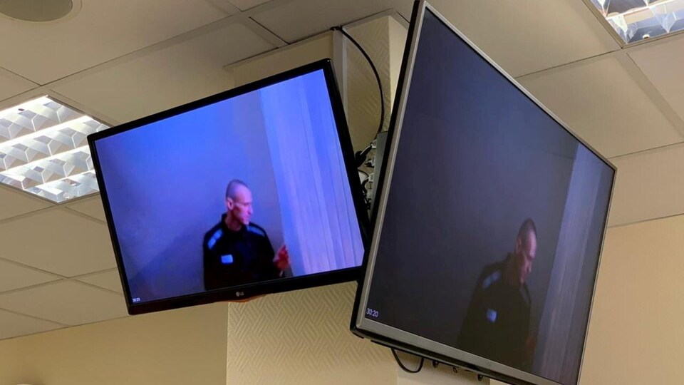 Deux écrans montrant un homme au crâne rasé en survêtement.