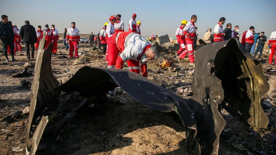 Des travailleurs du Croissant-Rouge vérifient les débris de l'avion PS752 d'Ukraine International Airlines.
