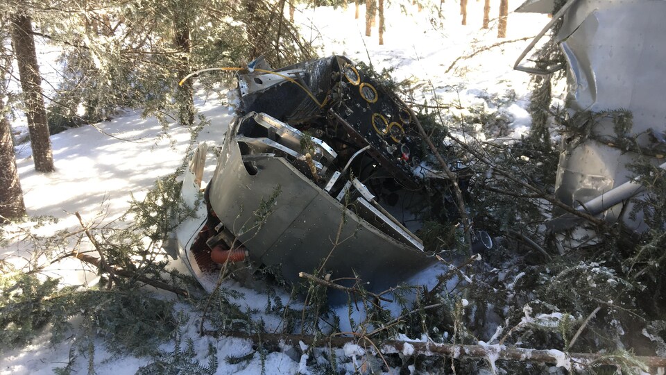 La partie avant d'un petit avion gît au sol, détaché du reste de l'appareil.