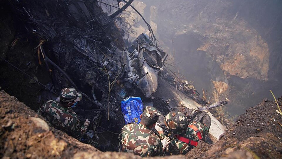 Kurtarma ekipleri 15 Ocak 2023'te Pokhara'da bir uçak kazasının olduğu yeri inceliyor.