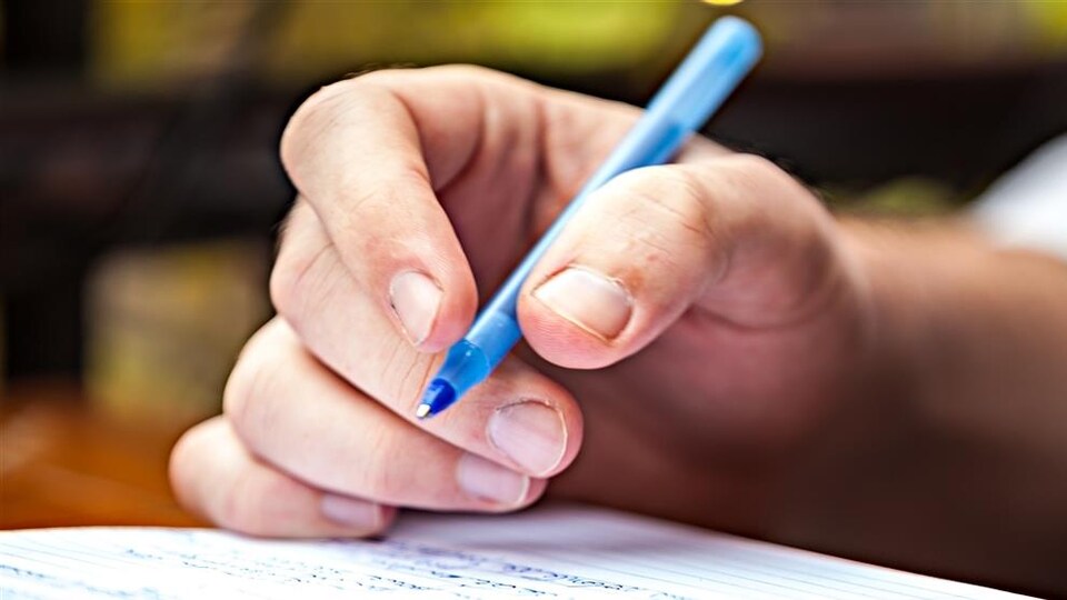 une main avec un crayon