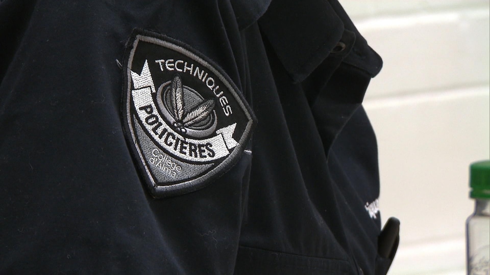 Un écusson sur lequel on peut lire « Techniques policières, Collège d'Alma ».