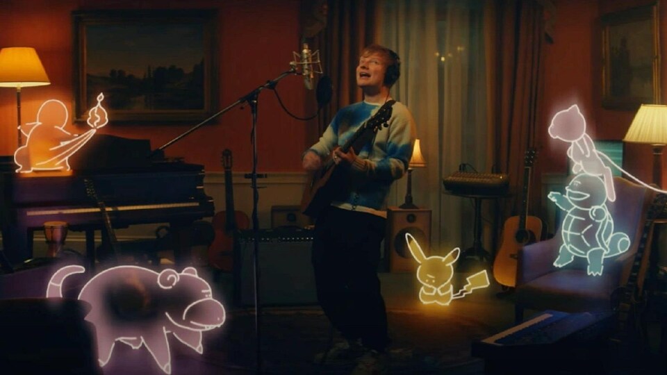 L'homme joue de la guitare dans un salon, dans lequel se trouvent cinq créatures phosphorescentes. 