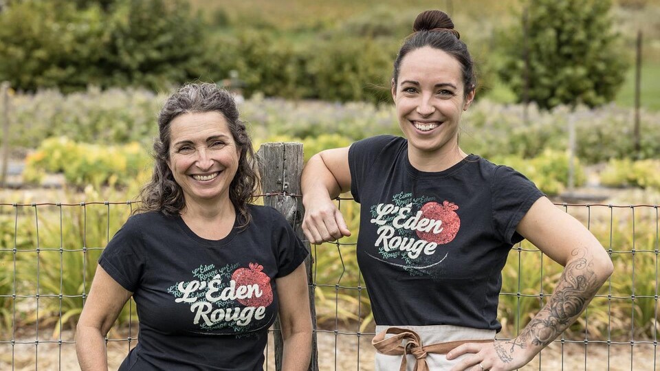 La propriétaire de l'Éden Rouge Anny Roy et sa fille Angèle-Ann posent devant une clôture.
