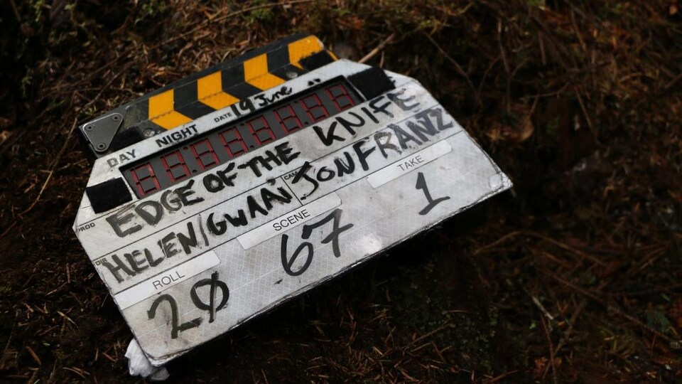 Une claquette pour le film «Edge of the Knife» est par terre sur le sol d'une forêt.
