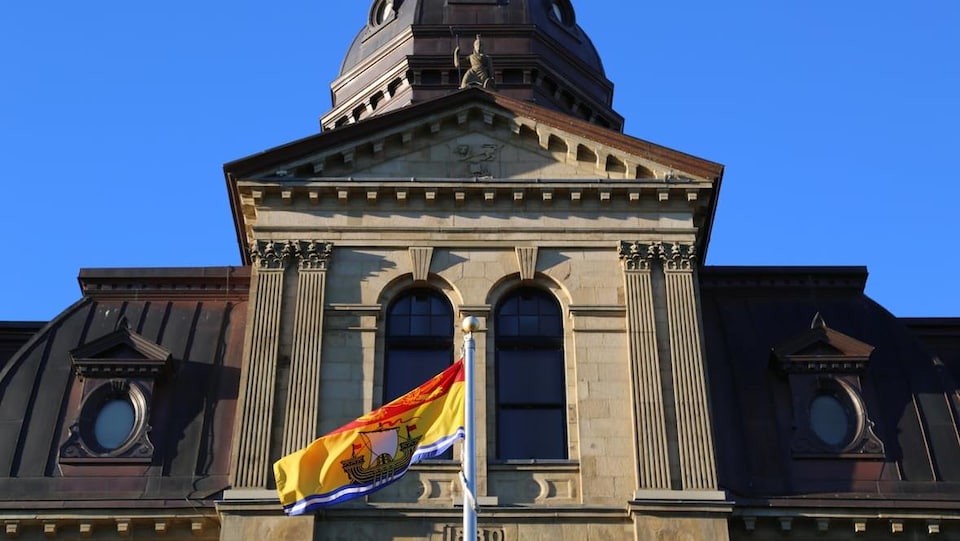 Le drapeau du Nouveau-Brunswick flotte devant l'Assemblée législative.