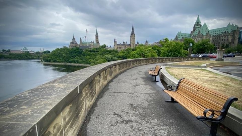 Le profil du parlement fédéral se détache d'un sentier le long de la rivière des Outaouais.