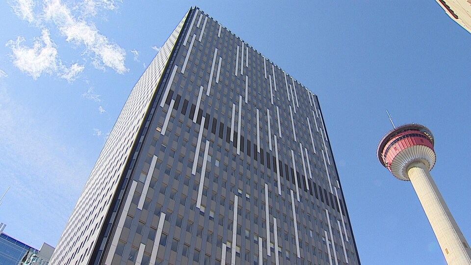 Un bâtiment commercial avec la tour de Calgary côte à côte.