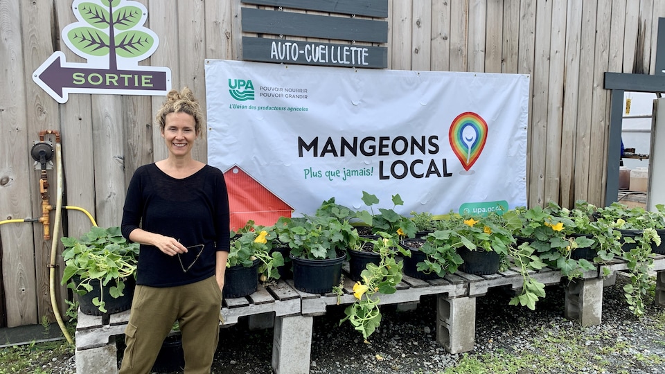 Édith Cochrane devant des plants de légumes.