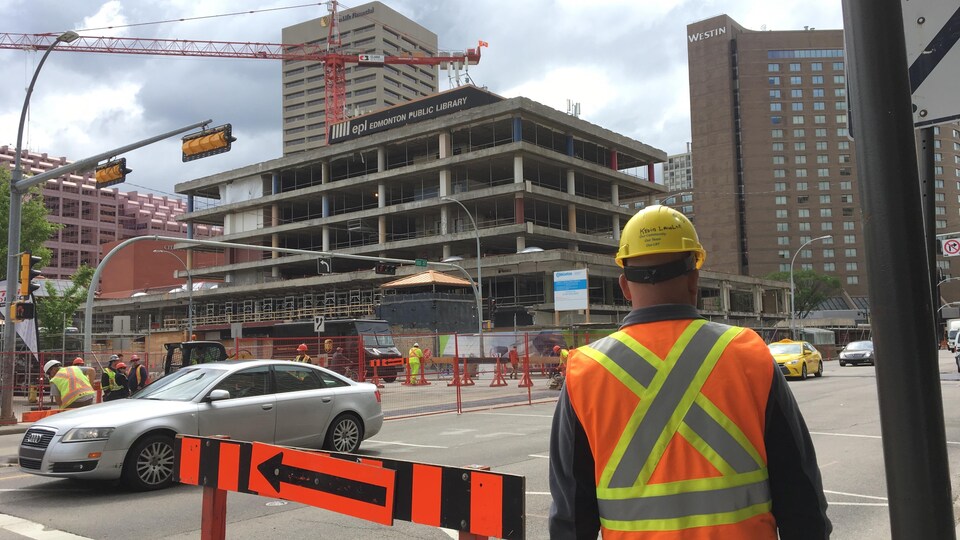 Un travailleur regarde un chantier de construction au centre-ville d'Edmononton.