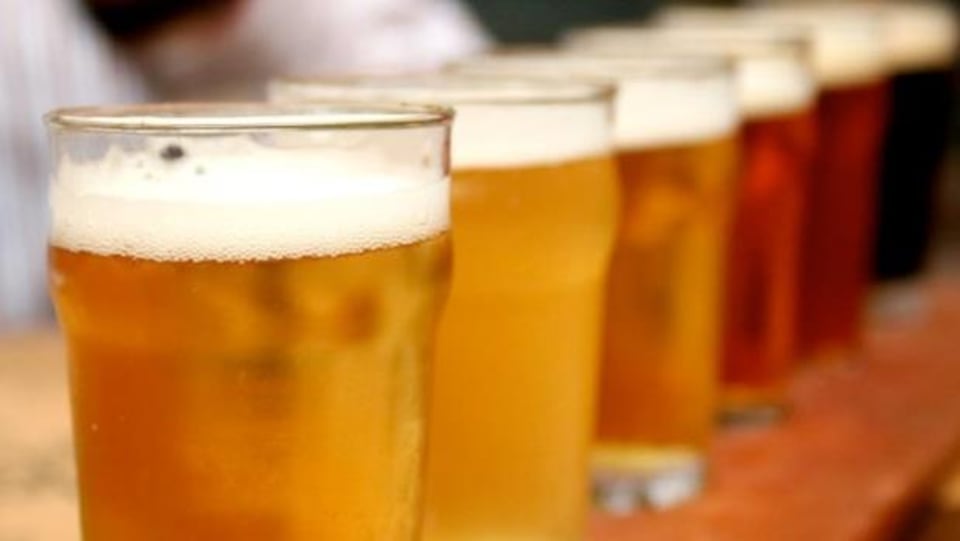 Des verres de bière alignés sur un comptoir.