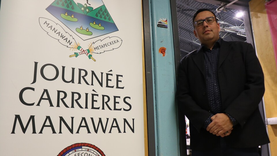 Sakay Ottawa pose à côté d'un panneau avec l'inscription « Journée carrières Manawan ».