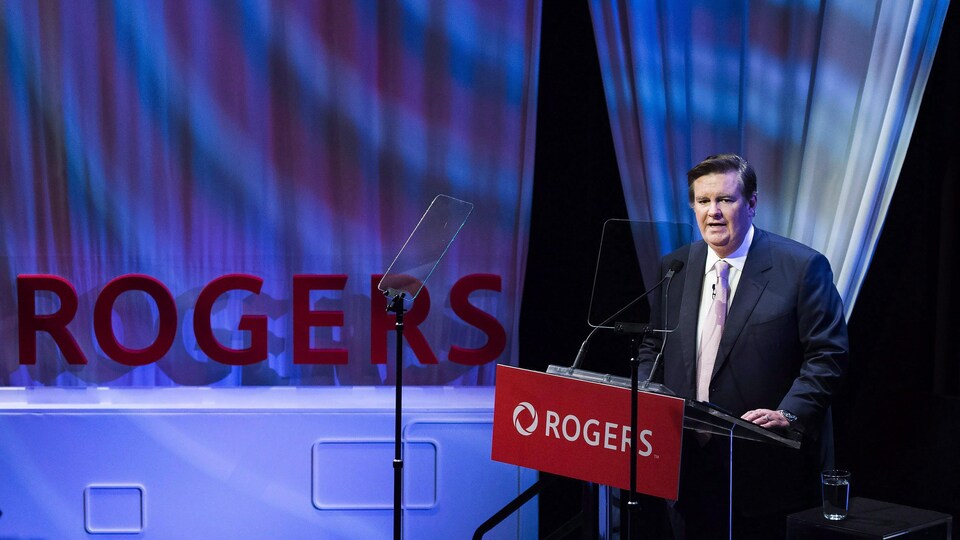 Edward Rogers prononce une allocution derrière un lutrin dans une salle de conférence.