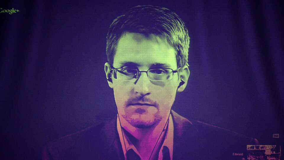 Edward Snowden parle en vidéoconférence sur un grand écran.