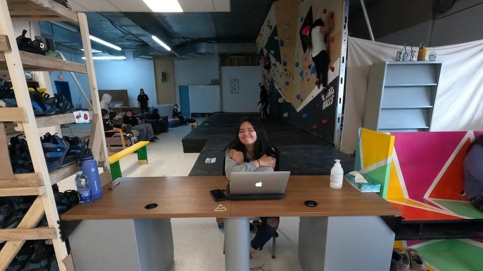 The girl was sitting behind a laptop at the Eeyou Bouldering Center.