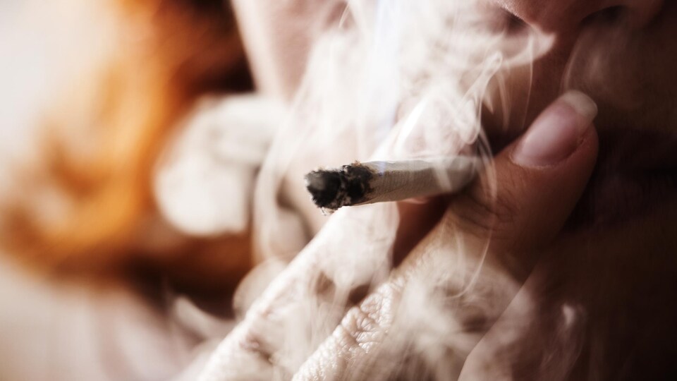 Woman puffs on a marijuana joint