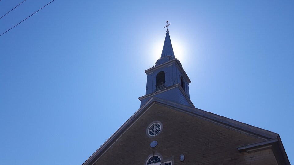 Le clocher d'une église sur fond de ciel bleu.