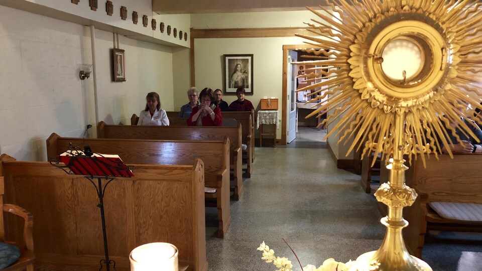 Des gens prient Ã  l'intÃ©rieur de la chapelle.