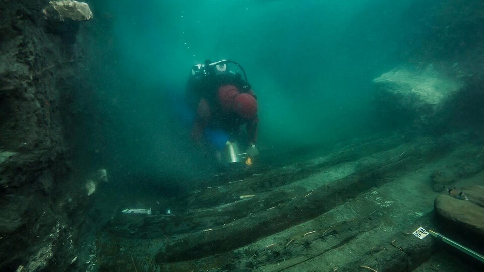 Un plongeur inspecte un ancien navire militaire.