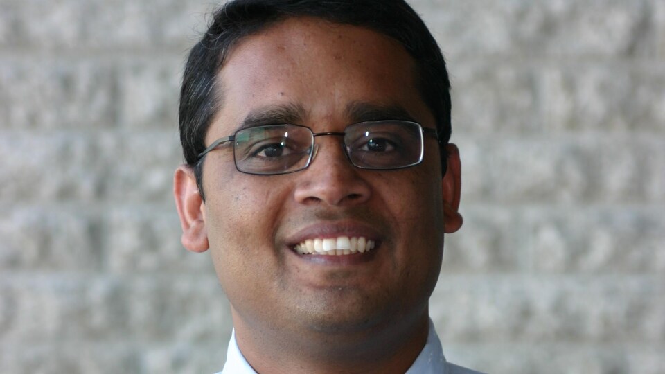 Ekram Hossain sourit sur une photo et regarde devant lui.