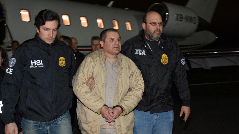 Le baron de la drogue du Mexique, Joaquin El Chapo Guzman, est escorté à son arrivée à l'aéroport Long Island MacArthur à New York, aux États-Unis, le 19 janvier 2017, après son extradition du Mexique.