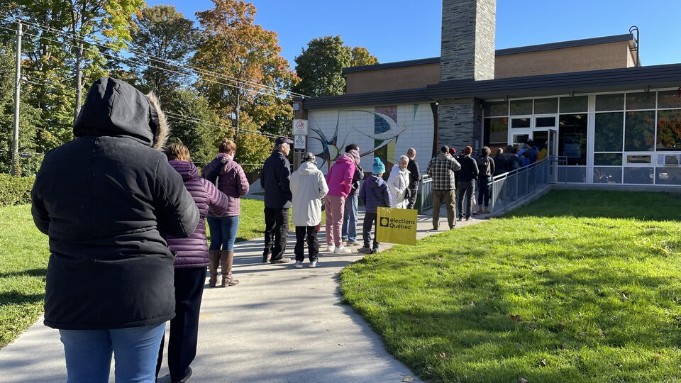 Des électeurs font la file au bureau de vote.