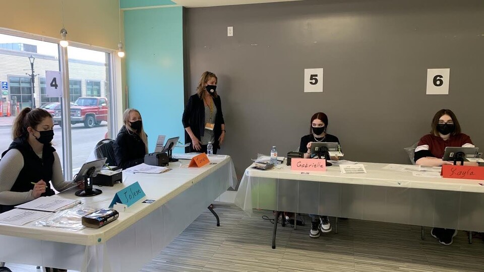 Des jeunes qui travaillent dans un bureau de scrutin.