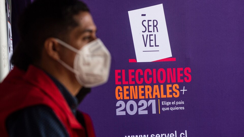 Un homme devant un signe du service des élections du Chili. 