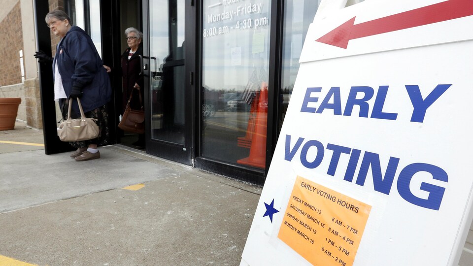 Deux femmes sortent d'un bureau de vote.