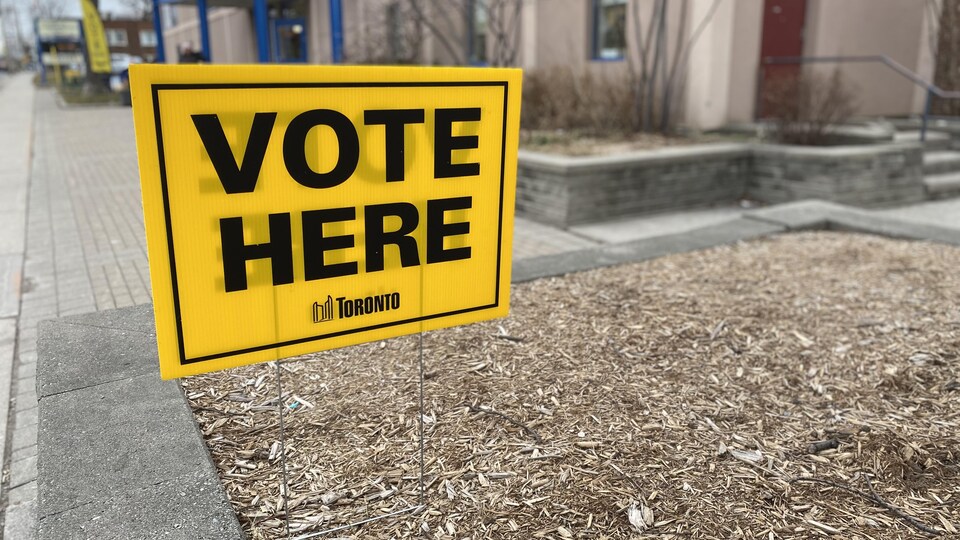 Affiche avec l'inscription « Vote Here » de la Ville de Toronto devant le Centre communautaire d'East York.