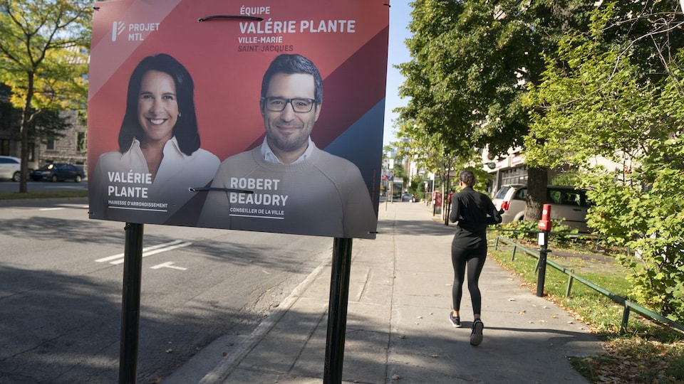Une joggeuse passe près d'une pancarte électorale de Projet Montréal.